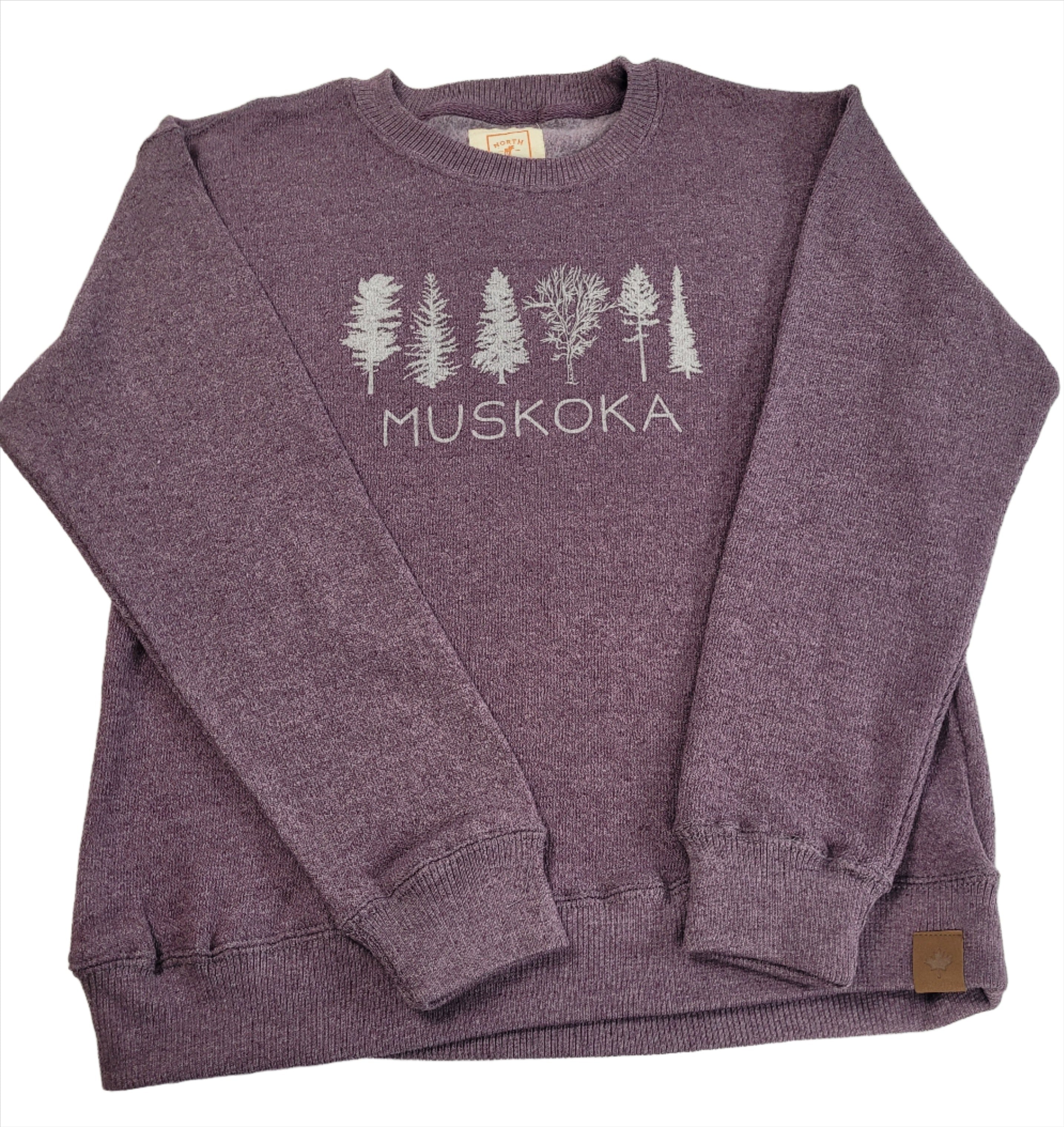 Plum purple Muskoka sweatshirt with ribbed cuffs and a graphic print of trees and the text 'MUSKOKA' on the front.