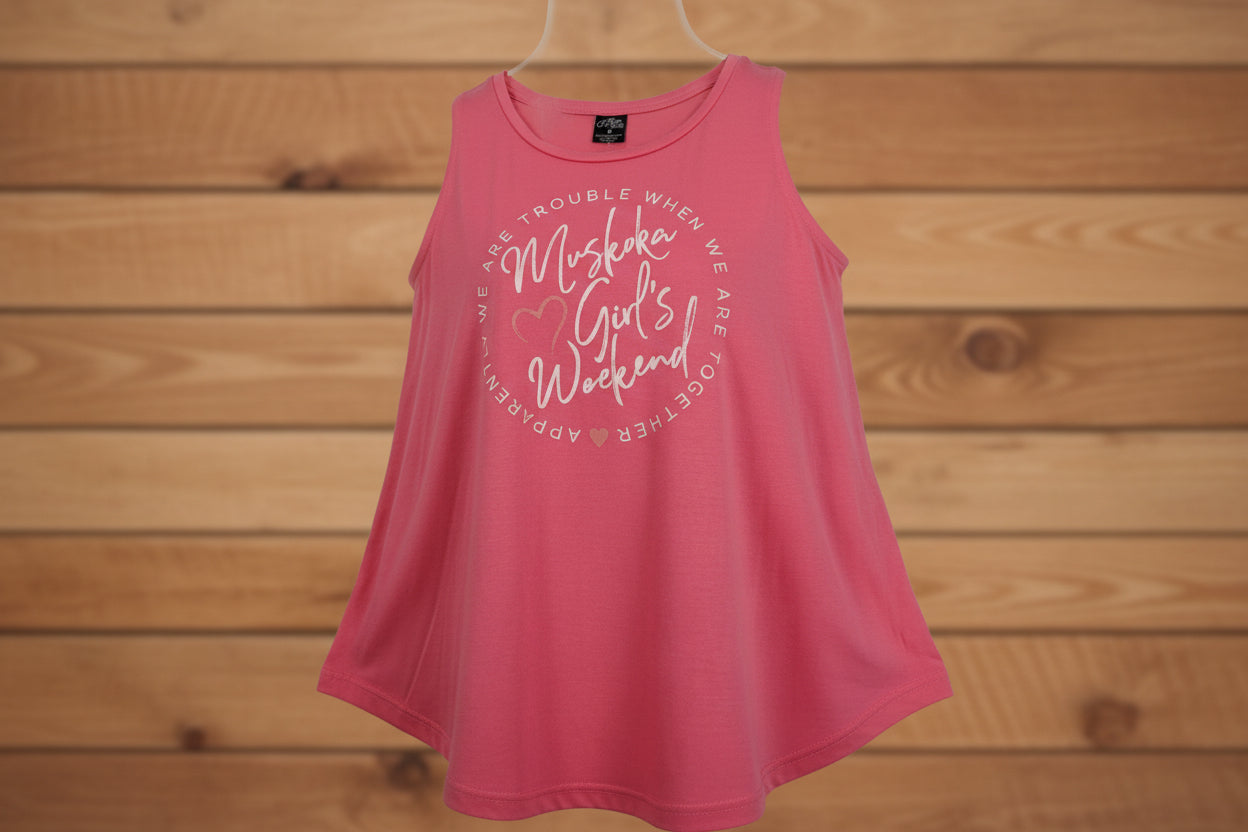 A pink flowy tank top with the text 'Muskoka Girls Weekend' printed on the front.